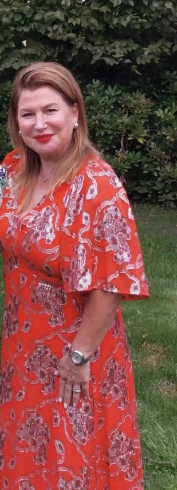 Ilse, klant van Focus-On, in een rode jurk in de tuin