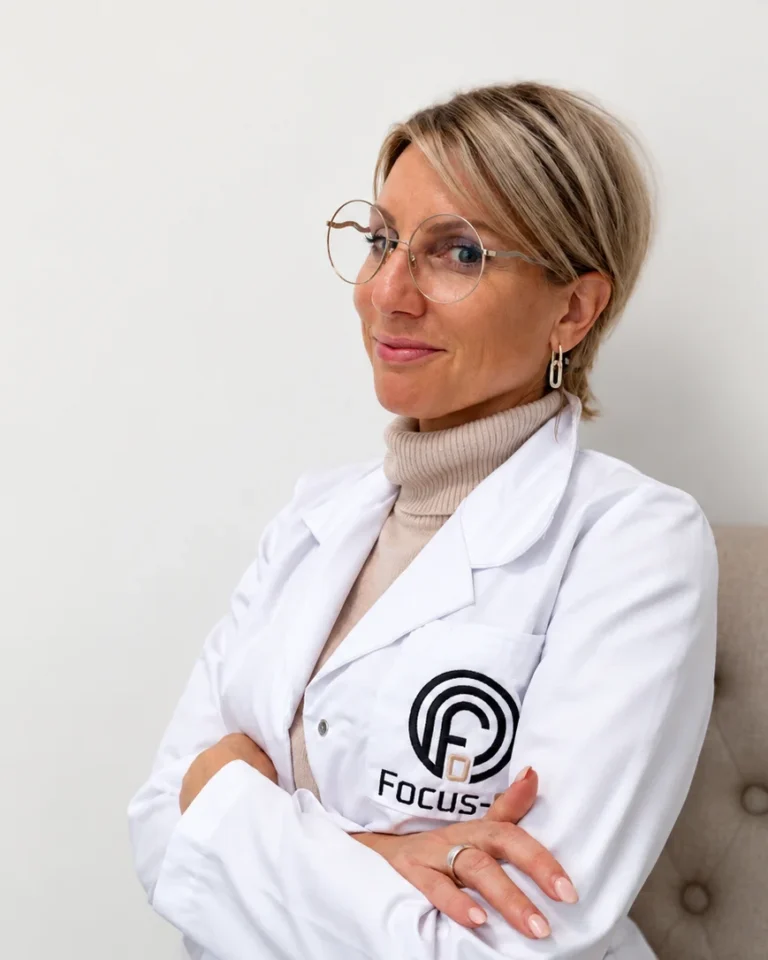 Kitty Goedgezelschap, oprichter van Focus-On, met gekruiste armen in haar witte Focus-On-jas