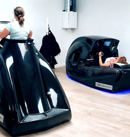 Twee Vacushaper-toestellen in de studio, een klant traint, een andere ligt in de cabine